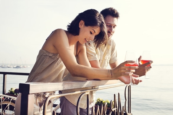 Couple talking while having spritz in a lake view terrace - What Does A Taurus Man Like In An Aquarius Woman